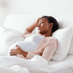 Pregnant Woman lying down in bed relaxing