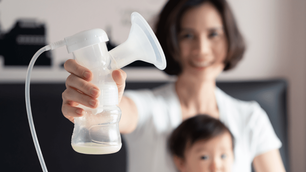 Woman-holding-breast-pump-in-foreground-with-child-in-background