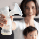 Woman-holding-breast-pump-in-foreground-with-child-in-background