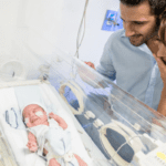 Mother and father looking at their NICU baby