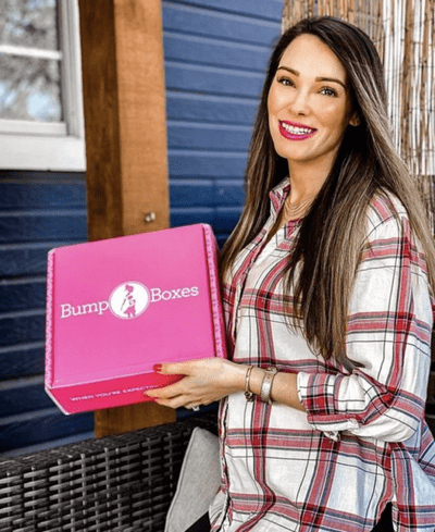 A woman is holding up a Bump Boxes delivery